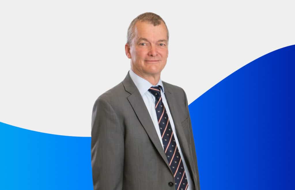 a businessman in a suit smiles for a portrait