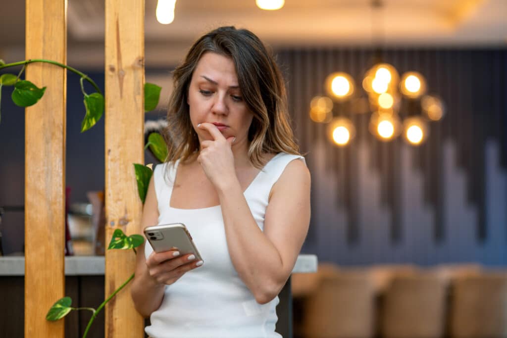 Woman who received a spam message on her cell phone reads the message.